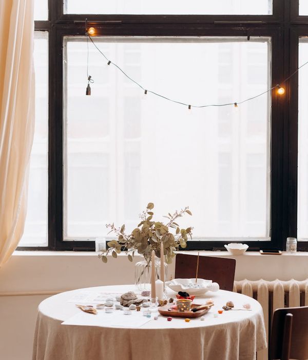 Woman in a calm, balanced yoga pose in a dark, minimalist setting.